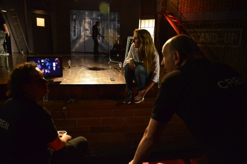 Equipo técnico conversando frente al escenario de ladrillo de un ciclo de stand-up de Comedy Central