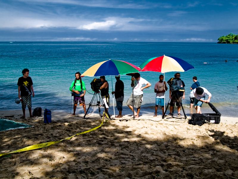 Equipo sobre una playa con sombrillas durante la grabación de Survivor, Panamá